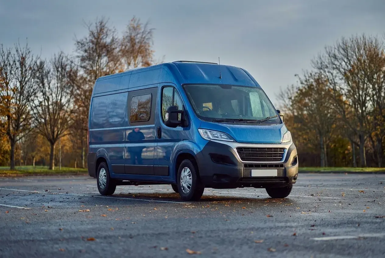 A used motorhome parked on a quiet British forecourt in soft low light on a crisp autumn morning.