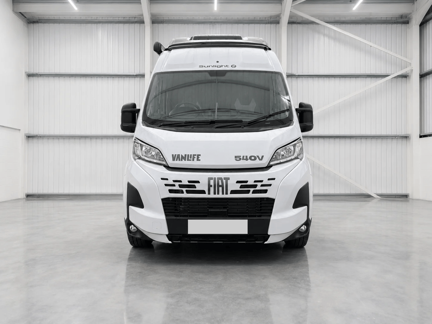 White Fiat Ducato Sunlight Vanlife campervan front view in showroom with registration plate.